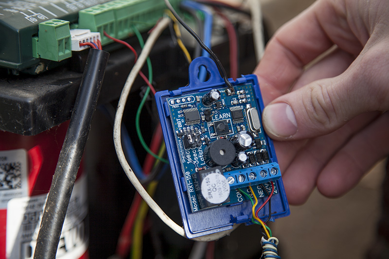A GuardCell receiver board being installed at a gate motor